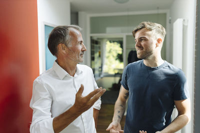 Father and son discussing while standing at home