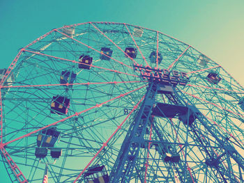 Low angle view of ferris wheel against blue sky