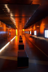 Empty corridor along illuminated lights