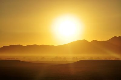 Scenic view of silhouette mountains against sky during sunset