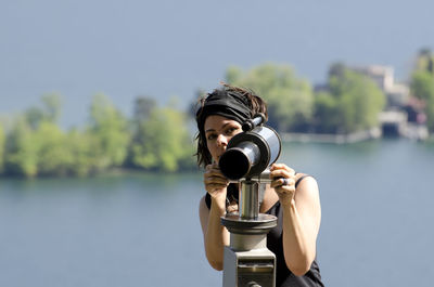 Close-up of man holding camera against river