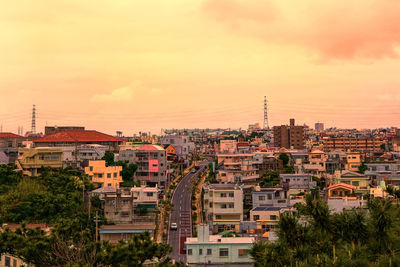 Townscape against cloudy sky during sunset