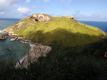 Scenic view of sea by mountains against sky