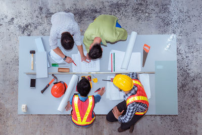 Directly above shot of engineers discussing plan