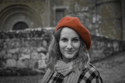 Portrait of woman wearing red hat against wall