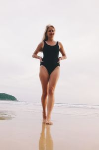 Full length of man standing on beach against sky