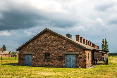 Old house on field against sky