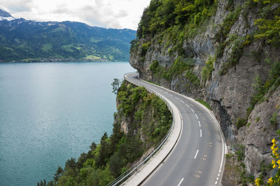 Scenic view of road by mountains against sky