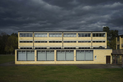 Bauhaus style building on field against dramatic sky