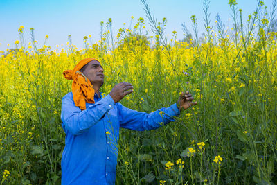 Woman standing on yellow flower field