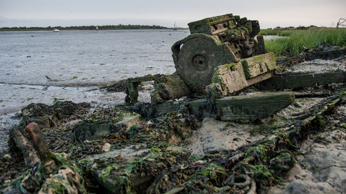 Abandoned built structure in water against sky