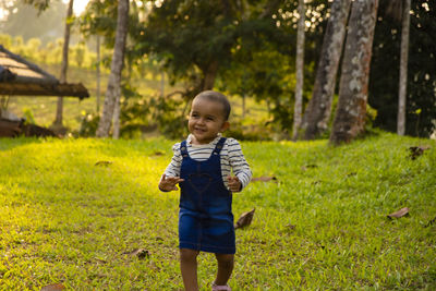 Baby girl running over the greenery 