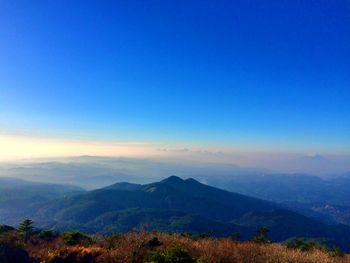 Scenic view of mountains against blue sky