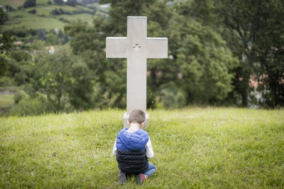 Boy with cross on grass