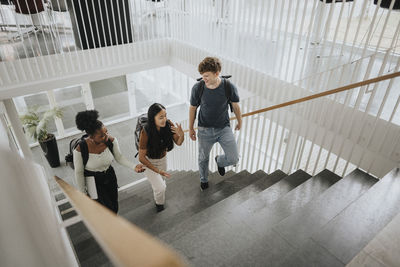 High angle view of multiracial male and female students moving up on steps in university