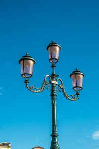 Typical venetian street light over a blue sky