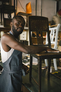 Portrait of male entrepreneur upcycling chair at workshop