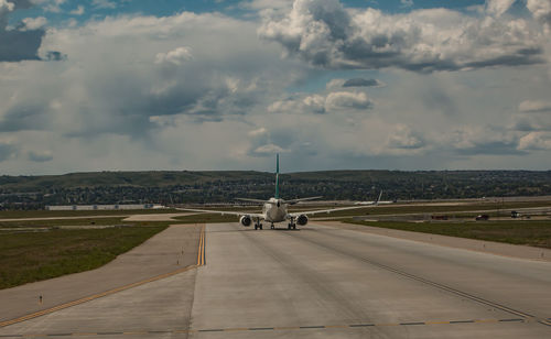 Airplane on runway against sky