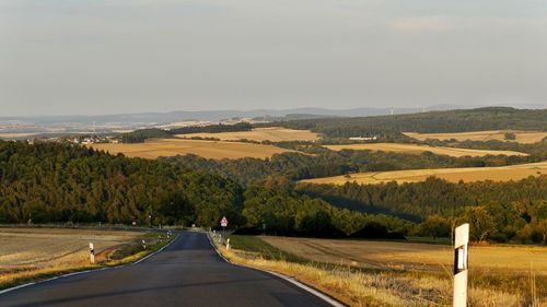 Road passing through landscape against sky