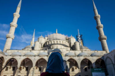 Rear view of woman against historic building