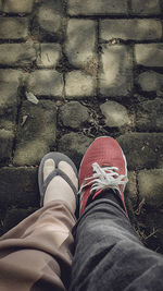 Low section of woman standing on footpath