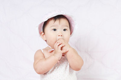 Cute baby girl sitting on bed at home