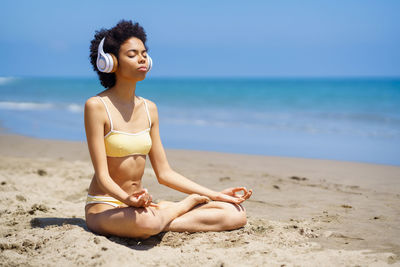 Young woman listening music white meditating