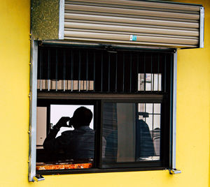 Rear view of people sitting outside building