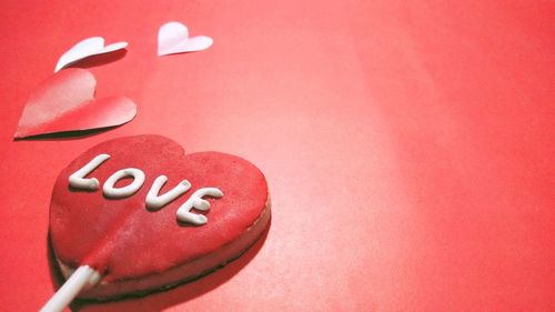 High angle view of heart shape on pink over red background