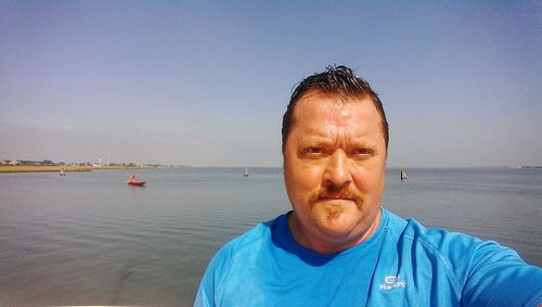 Portrait of man in sea against blue sky