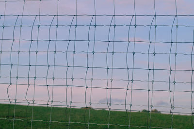 Fence against sky during sunset