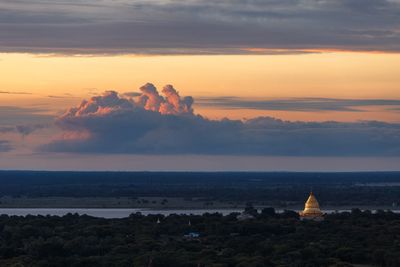 Scenic view of sea against cloudy sky during sunset