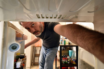 Man opening refrigerator door.