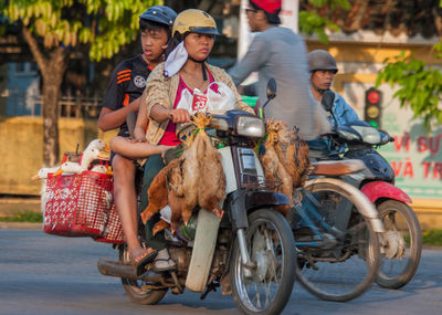 Rear view of people riding motorcycle