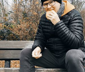 Midsection of man sitting on bench