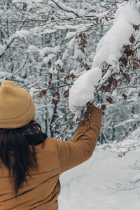 Rear view of woman standing on snow