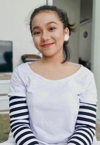 Portrait of smiling teenage girl at home