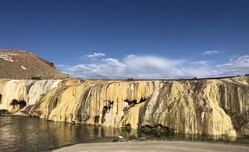 Scenic view of waterfall against sky