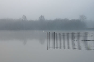 Scenic view of lake against sky during foggy weather