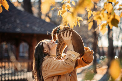 Happy woman with cute english cocker spaniel puppy on a walk in autumn forest. happy dog and woman