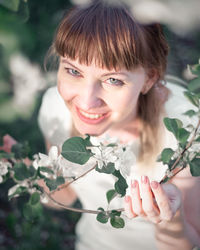 Young woman portrait on the blooming apple trees background