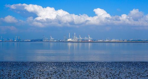 Commercial dock by sea against sky