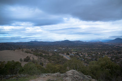 Scenic view of townscape and mountains against sky