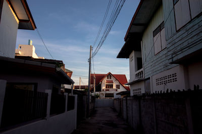 Alley amidst buildings in city against sky