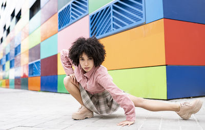 Young female dancer staring while dancing on footpath