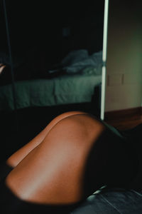 Midsection of woman sleeping on bed at home