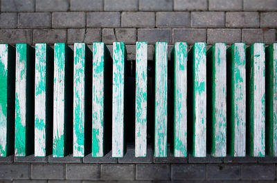 High angle view of metallic fence on footpath against wall