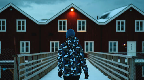 Rear view of woman standing against building