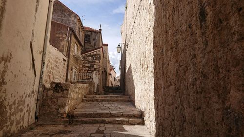 Narrow alley amidst buildings against sky