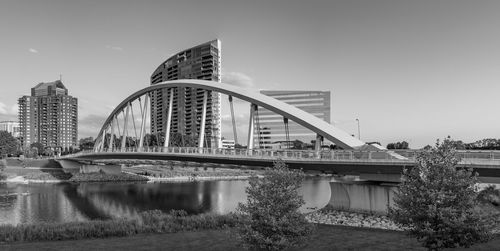 Bridge over river against buildings in city